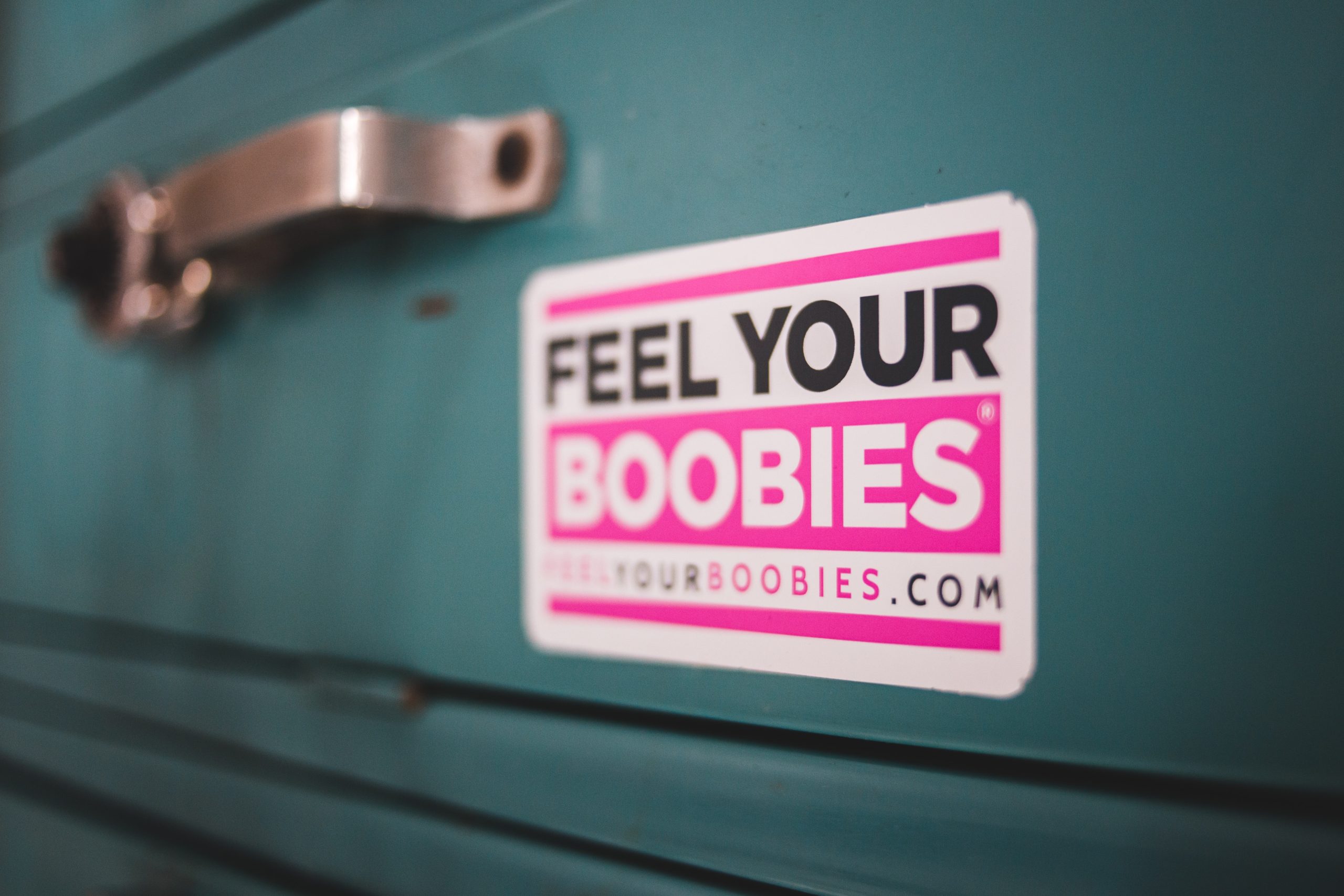 feel your boobies sticker on an old teal car.