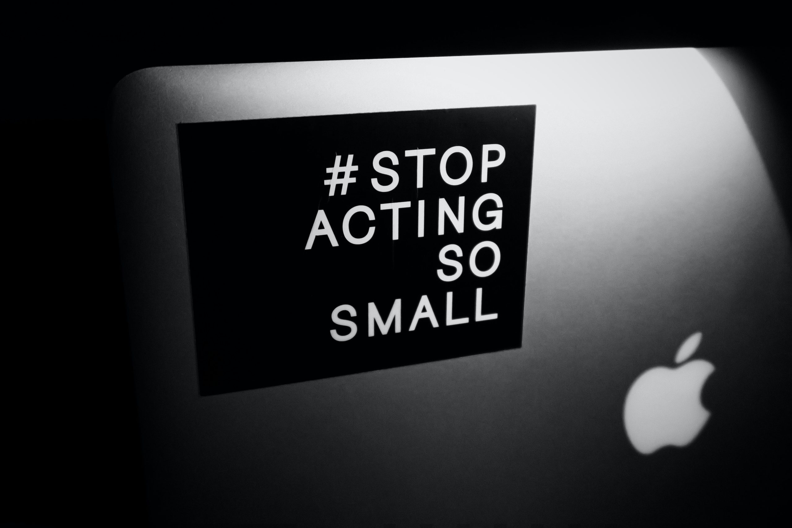 "#stop acting so small" sticker on a grey macbook.