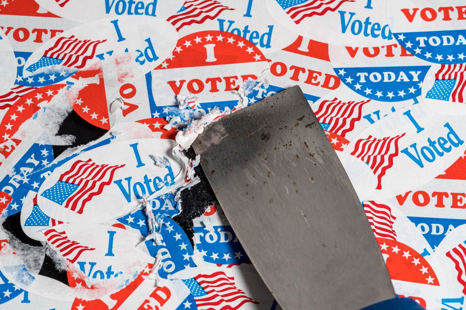 a scraper removing "i voted" stickers from a wall.